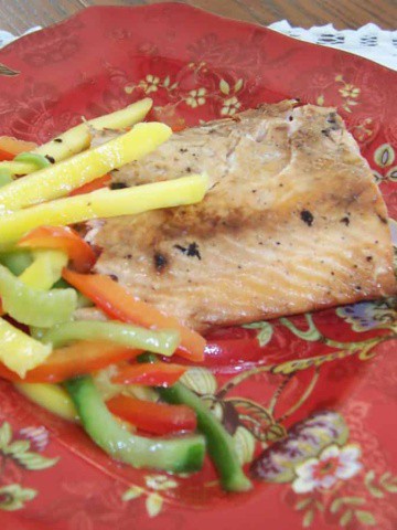 Grilled salmon with ginger and soy sauce on red Oriental pattern plate