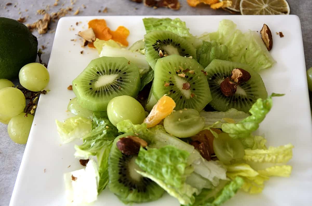 Salad greens with green grapes, kiwi fruit, mandarin pieces and toasted almonds.