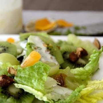 Salad greens with green grapes, kiwi fruit, mandarin pieces and toasted almonds.
