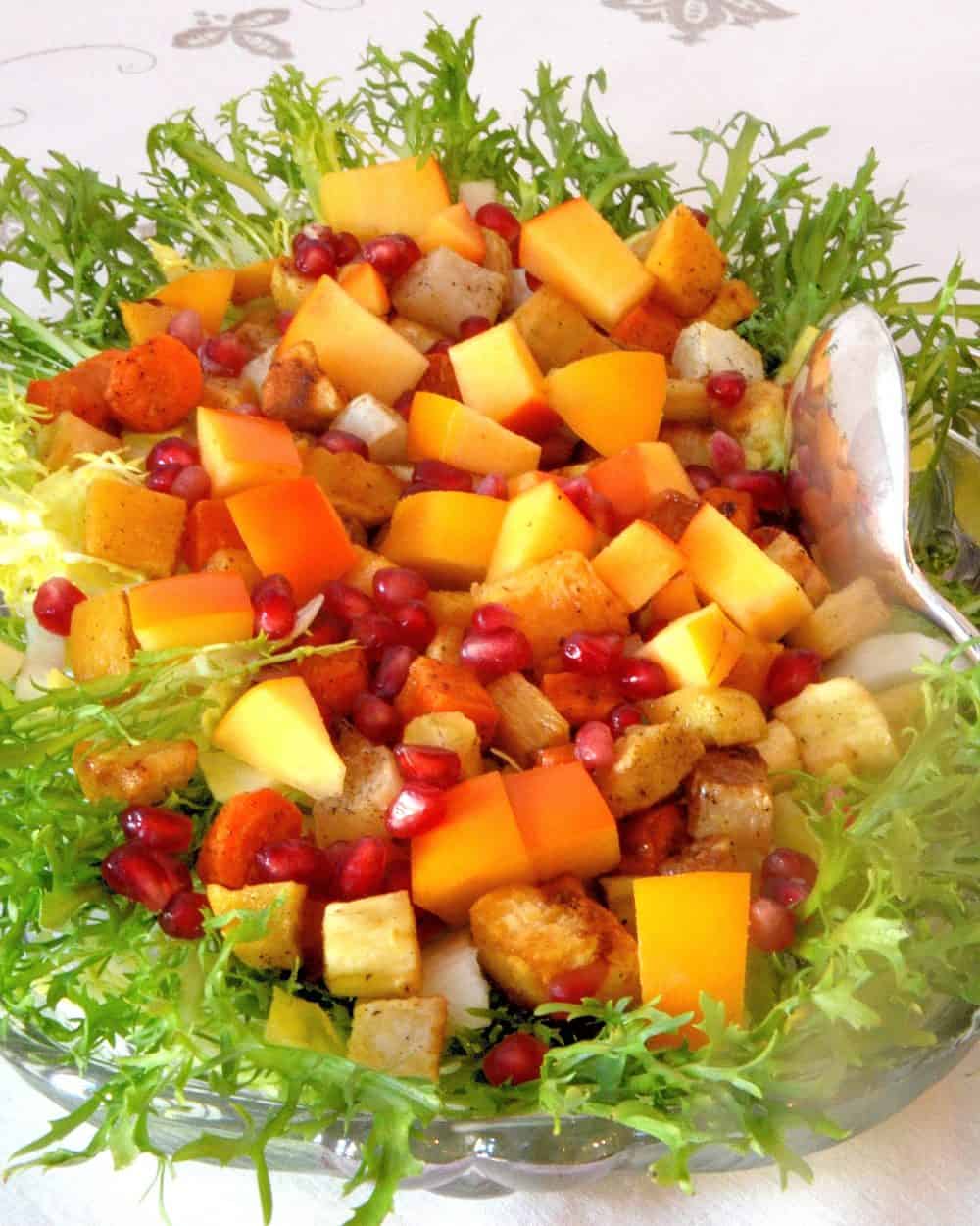 Persimmons and pomegranate seeds on frisee lettuce
