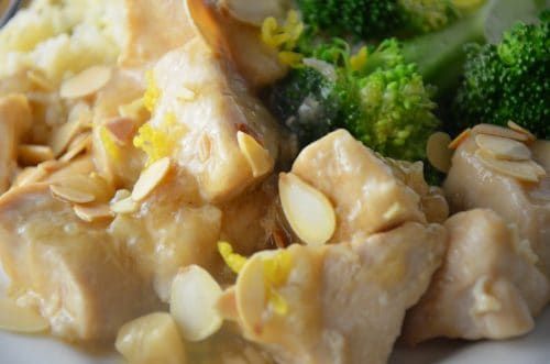 Close up of cubes of chicken in lemoncello sauce with almonds and broccoli.