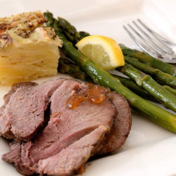 Slices of roast lamb with Major Grey's Chutney, Potatoes Anna and roasted asparagus.