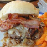 Bourbon flavoured hamburger on a Kaiser bun stacked with caramelized onions, mushrooms, melted cheese and bacon.