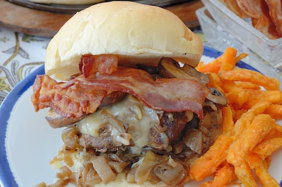 Bourbon flavoured hamburger on a Kaiser bun stacked with caramelized onions, mushrooms, melted cheese and bacon.