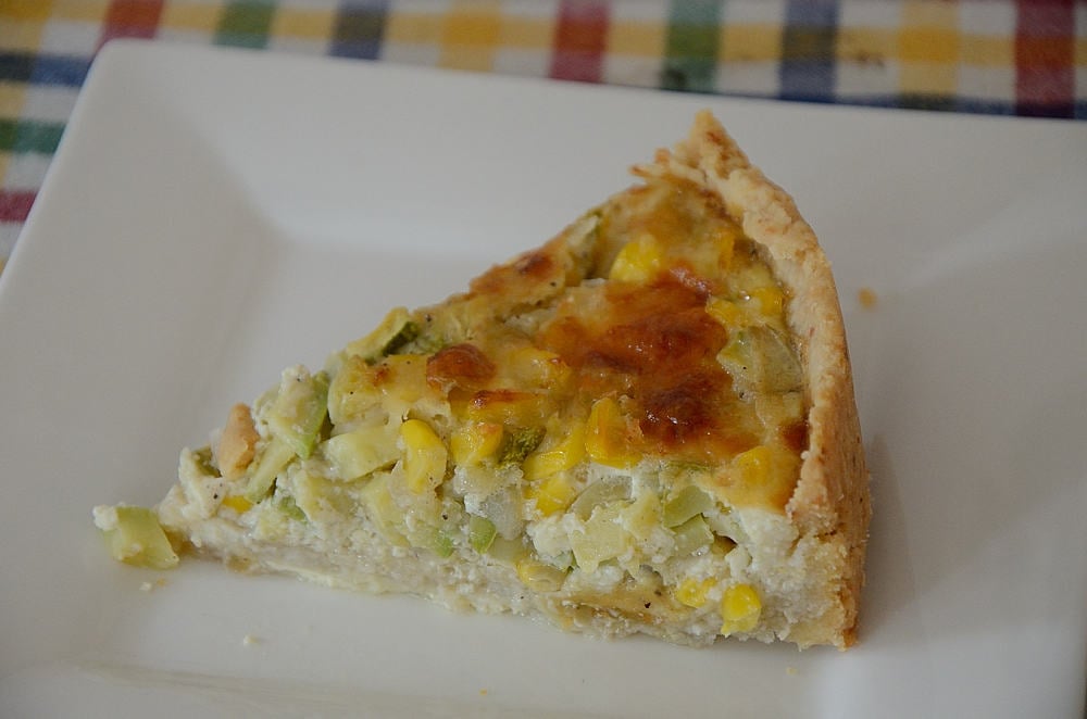 Piece of summer corn quiche with parmesan pastry on a plate