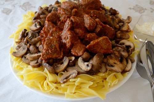 goulash stew on a bed of noodles on a platter