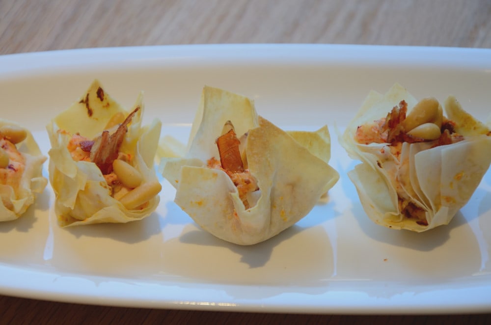Phyllo pastry cups on a white serving dish.