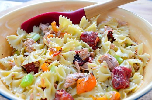 Bow Tie pasta in a bowl with roasted peppers and tomatoes.