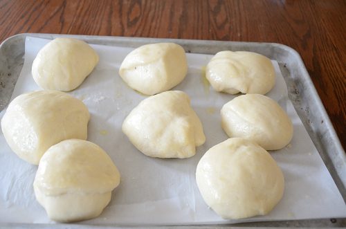 Raw cheese buns on baking sheet