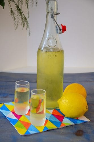 Limoncello bottle with lemons and shot glasses