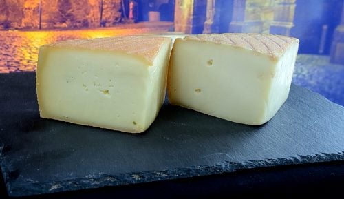 Block of raclette cheese on a tray.