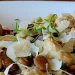 Penne in a bowl with chicken, rosemary and mushrooms.
