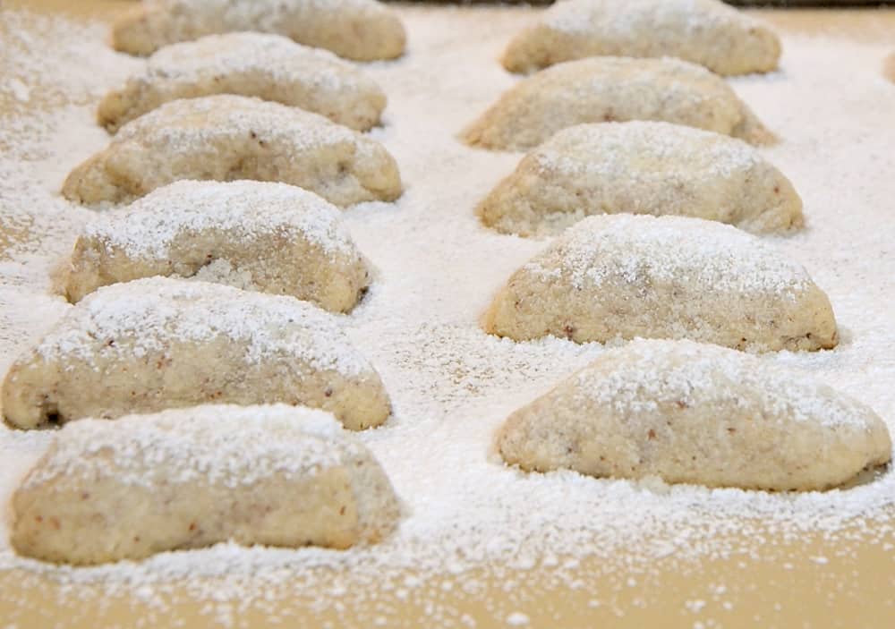 German Vanilla Crescents dusted with vanilla sugar on baking sheet