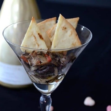 Creamed mushrooms served in a martini glass with pita chips