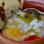 Baked eggs on bed of tortillas with Mexican Green sauce