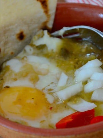 Baked eggs on bed of tortillas with Mexican Green sauce