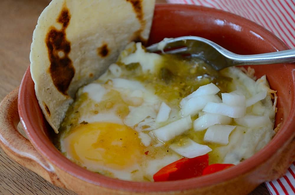 Baked eggs on bed of tortillas with Mexican Green sauce