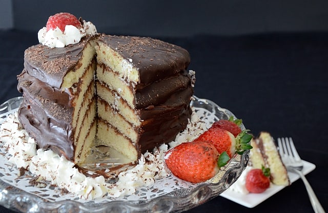 Chocolate layer cake garnished with whipped cream and strawberries