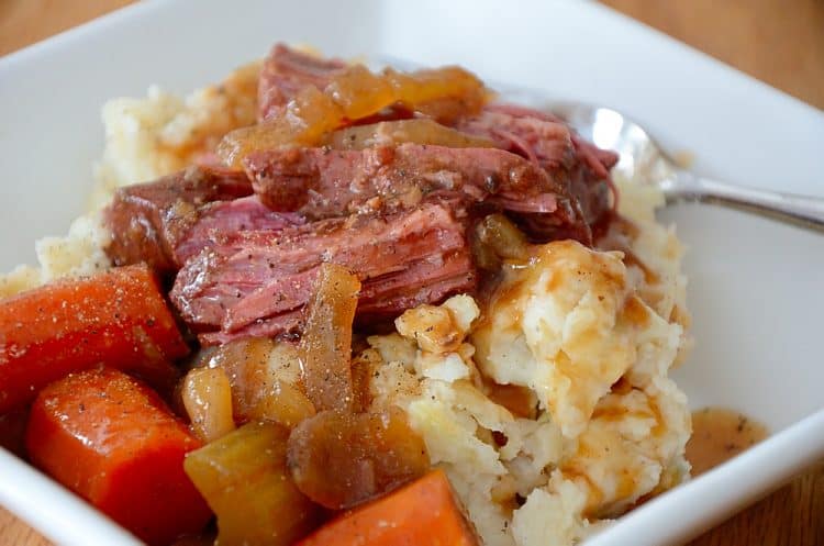 Brisket in Guinness gravy with carrots and celery in a bowl over Colcannon