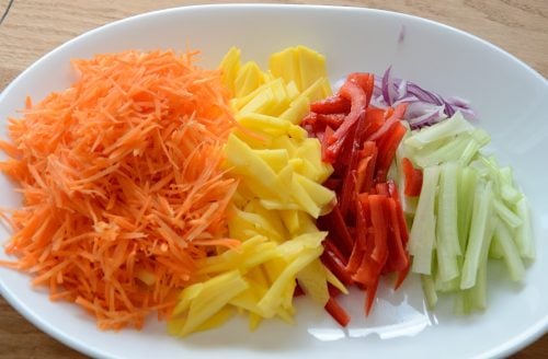 Plate of julienned carrots, mango, pepper and celery