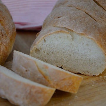 French baguette on a cutting board, sliced.