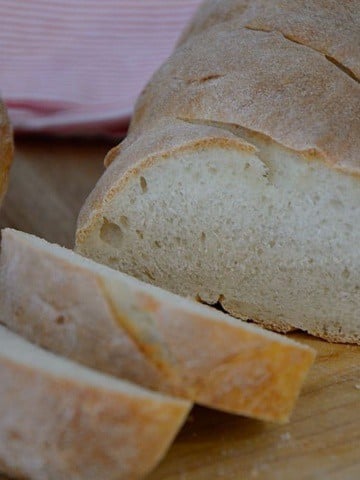 French baguette on a cutting board, sliced.