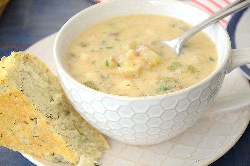 A cup of thick Scallop chowder with a wedge of dill bread