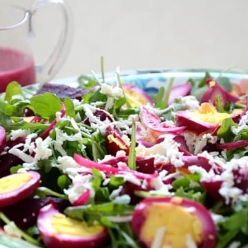 Salad with pickled eggs, beets and feta on a bed of greens