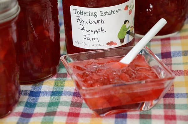 Rhubarb Pineapple Freezer Jam in a small dish with jam jars behind.