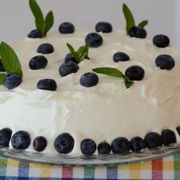 angel food cake with whipped cream frosting and blueberry mint decorations