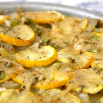 Rounds of summer squash and potatoes in a circular pan with herbs and cheese topping
