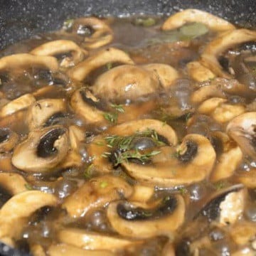 Skillet with balsamic mushroom sauce simmering