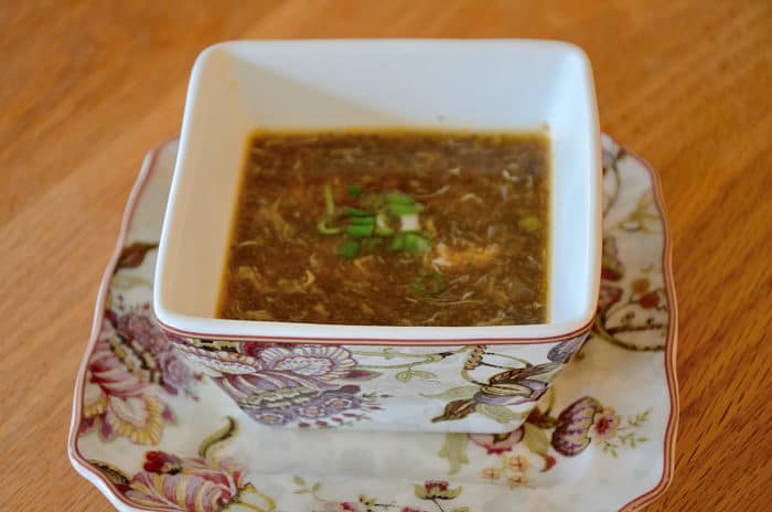 Square soup bowl filled with hot and sour mushroom soup