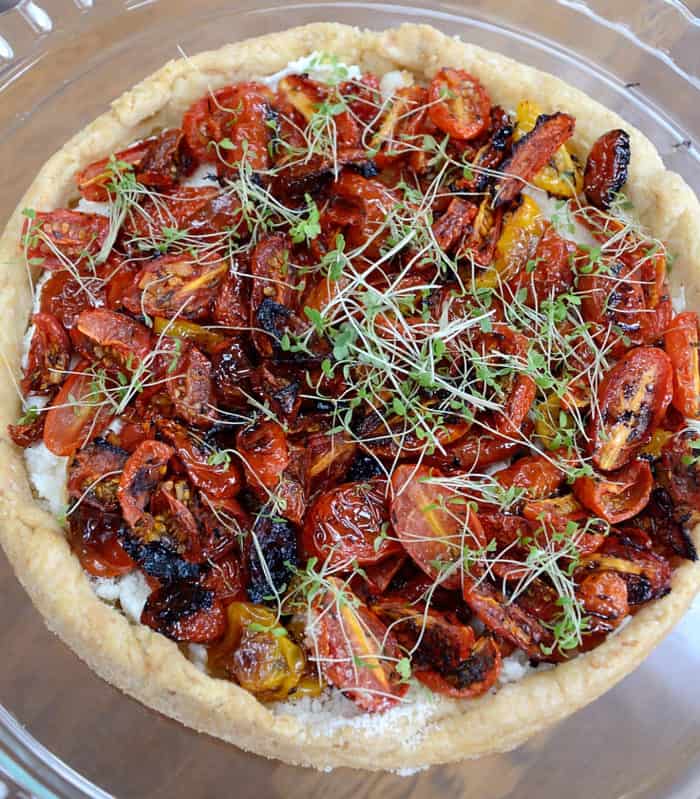 Tart filled with roasted tomatoes and garnished with microgreens