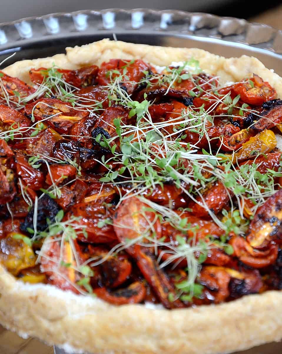 Tart filled with roasted tomatoes and garnished with microgreens