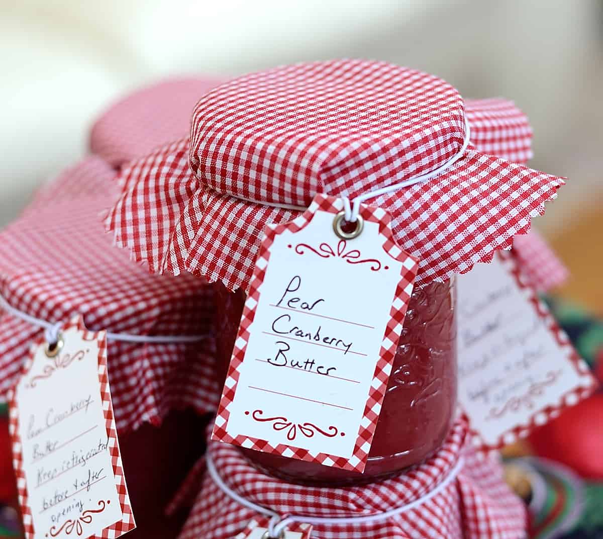 Half pint jar of pear cranberry butter with gingham cap and label