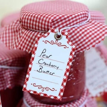 Half pint jar of pear cranberry butter with gingham cap and label