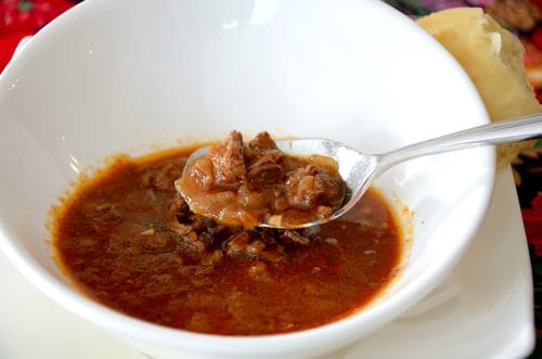 Bowl of goulash soup with a spoonful of broth and beef chunks.