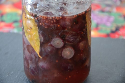 Pickled grapes in brine in a mason jar.
