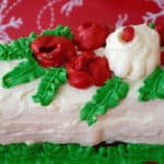 Yule Sandwich Log with red Rosette flowers and green leaves.