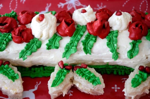 Yule Log Sandwich loaf deorated with roses and leaves and garnished with Holly shaped tea sandwiches