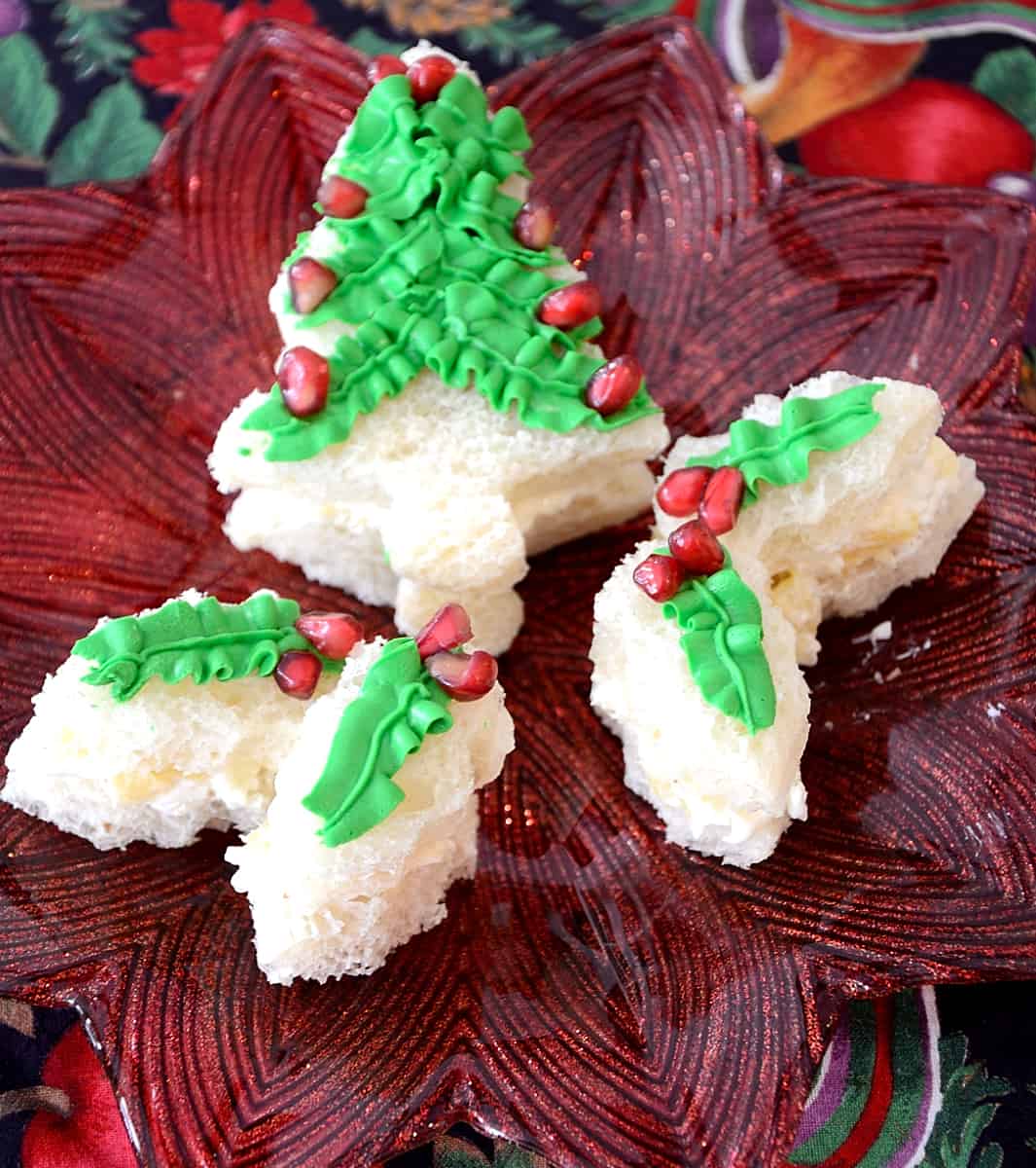 Christmas tree shaped sandwich with green cream cheese icing and pomegranate decorations