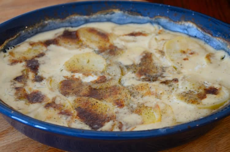 casserole with sliced potatoes baked in creamy goat cheese