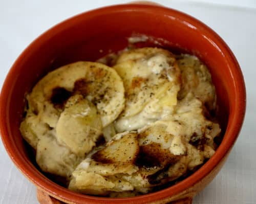 Small earthenware dish with Goat cheese and Garlic Potato Gratin