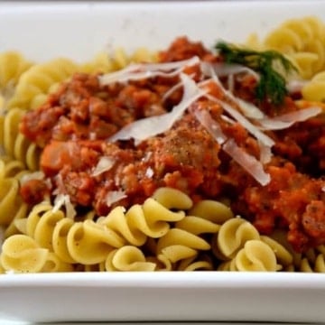 Dish or fusilli pasta with sausage and fennel sauce and fresh parmesan garnish