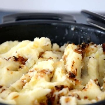 A casserole filled with mashed potatoes and golden caramelized shallots.