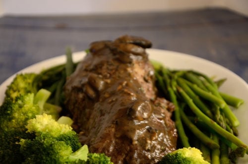 Chateaubriand tenderloin on a platter with broccoli, green beans
