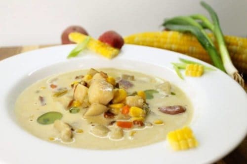 Bowl of creamy chowder with fresh corn and chunks of potato, celery and bacon