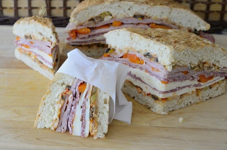 wedges of muffuletta sandwich filled with olive relish, cold meat and cheese slices