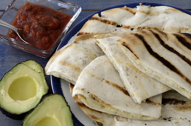 Plate of grilled chicken quesadillas with avocado and salsa
